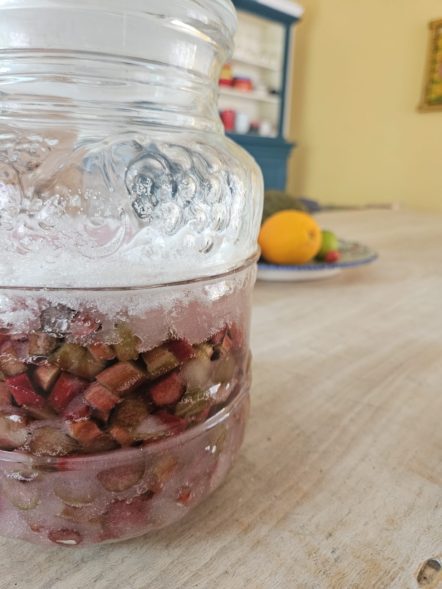 De suikerkap bovenop de pot, met onder de lagen rabarber de eerste siroop